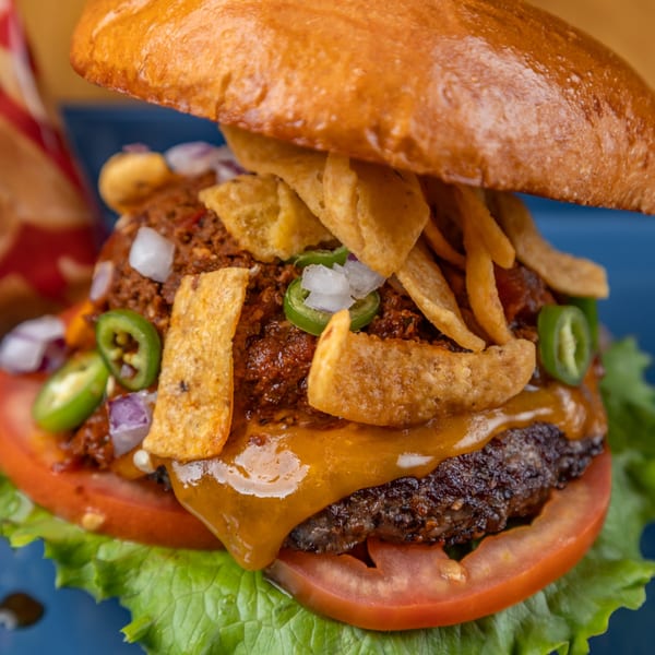 A LSA Burger Co. chili cheeseburger with Fritos, jalapeños, onions, lettuce, and tomato.