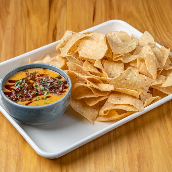 LSA Burger Co.'s queso dip with pulled pork and cilantro, served with tortilla chips.